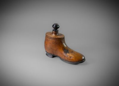 un vieux sabot en bois surmonté d'une boule noire