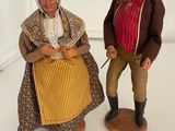 two figurines of a man and a woman standing next to each other