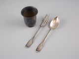 deux cuillères, une fourchette et une tasse posées sur une table
