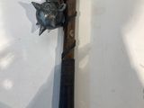 a metal object on a wooden stick with a bird on it