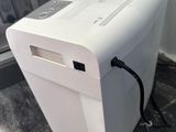 a white paper shredder sitting on a counter in front of a stove