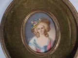a gold plate with a picture of a woman wearing a hat
