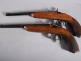 two old guns are sitting on a white surface