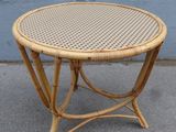 an image of a wicker table on a sidewalk with a blue wall in the background
