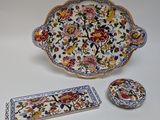 three pieces of pottery sitting on a white surface