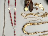 a lot of necklaces, bracelets, and other items on the table