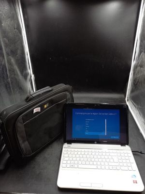 un ordinateur portable posé sur une table, avec un sac à côté