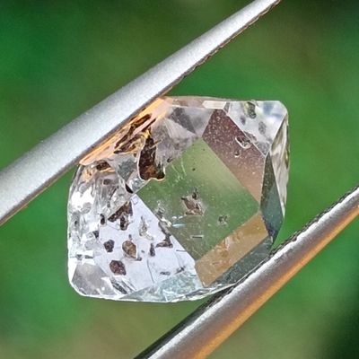 a diamond that is being held by a pair of tongs
