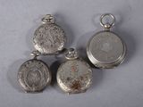 three silver pocket watches are sitting next to each other on a table