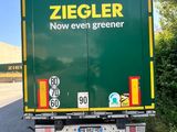 a green truck that is driving down the road