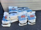 plusieurs sacs de riz posés par terre à côté d'un bâtiment
