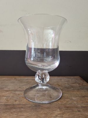 a clear glass vase sitting on a wooden table