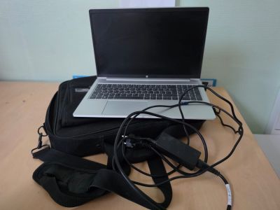 a laptop computer sitting on top of a bag on a table