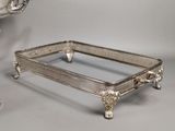 two silver trays with handles and handles are on a table