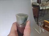 a person holding a glass in their hand in front of a mirror