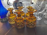 five glass vases sitting on a table next to a blue vase