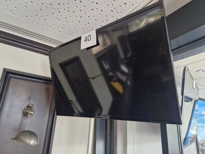 a flat screen tv hanging from the ceiling in a room