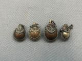 three antique silver and gold brooches on a gray surface