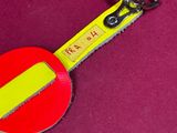 a yellow and red keychain with a red and yellow button
