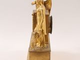 an image of a gold statue of a woman holding a basket