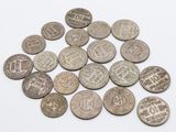 un gros plan sur un tas de vieilles pièces de monnaie posées sur une surface blanche