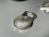 a silver bottle opener sitting on a table next to other items
