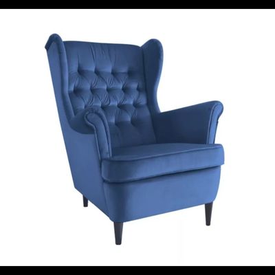 Le fauteuil bleu est recouvert d'un tissu à boutons au niveau du dossier.