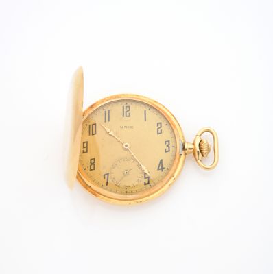 une montre de poche en or sur une surface blanche