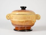 pot en céramique jaune et marron avec des anses sur un fond blanc