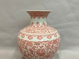 un vase rouge et blanc posé sur une table
