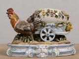 a figurine of a chicken and a cart on a table