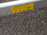 a yellow sign on the side of a metal fence