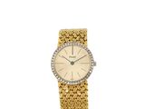 une montre-bracelet pour femme avec un bracelet en or et une lunette sertie de diamants