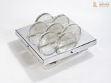 a silver plate with a bunch of coins in it