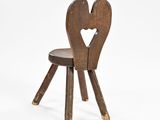 a small wooden chair with a heart on the back