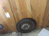 a wheel that is sitting on the floor next to a wooden wall