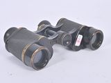 pair of binoculars on a white surface with a white background