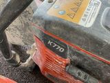 a small chainsaw sitting on the floor next to a car