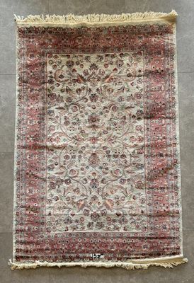 un tapis persan ancien avec un motif floral et des franges