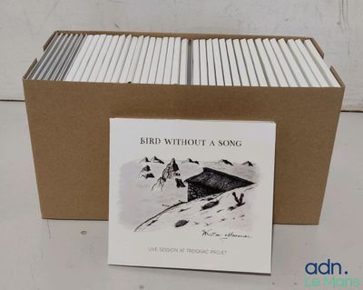 une boîte de livres posée sur une table à côté d'une autre boîte de livres