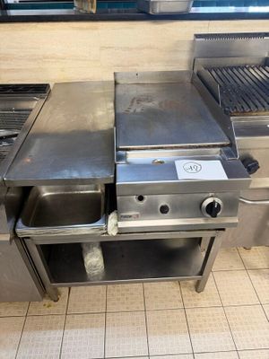 a large stainless steel grill in a commercial kitchen