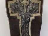 a brown vest with a cross on it on a mannequin stand