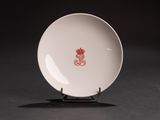 a white plate with a red design on it