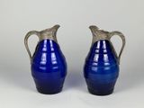une paire de vases en verre bleu avec des anses en argent sur fond blanc