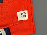 un maillot orange orné d'une rayure bleue et blanche