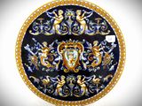 a blue and gold plate with a picture of angels on it