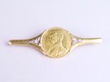une image représentant une bague en or et diamants, avec une pièce de monnaie au centre