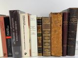 several old books are lined up in a row on a white surface