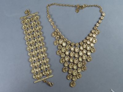 un ensemble composé d'un collier et d'un bracelet en or posé sur une table