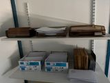 a shelf with several boxes and papers on it